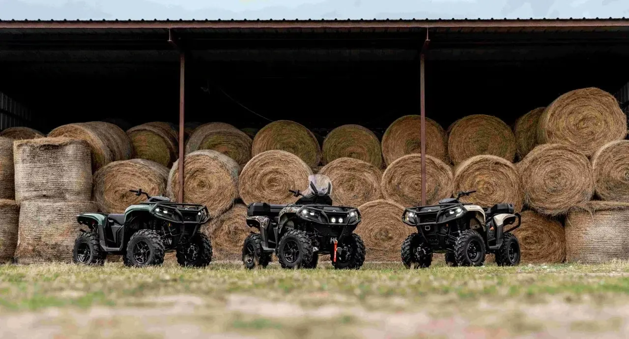 Tre fyrhjulingar framför höbalar